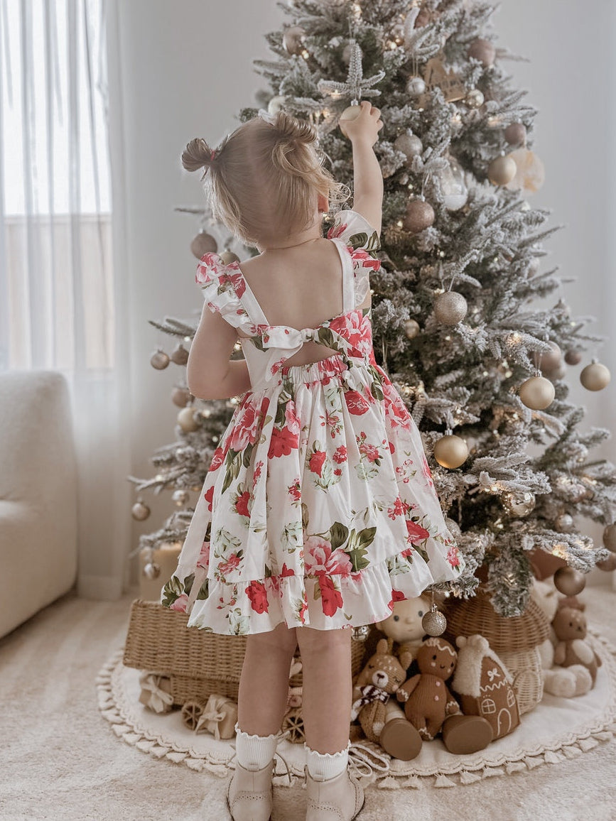 Faith Girls Christmas Rose Dress - Christmas Dresses and RompersGirl wearing Faith Girls Christmas Rose Dress with red and green floral print at family Christmas gathering
