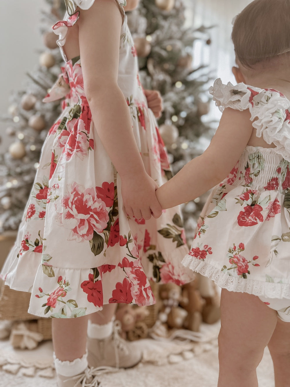 Detail shot of floral print fabric – red and green Christmas flowers on white cotton background