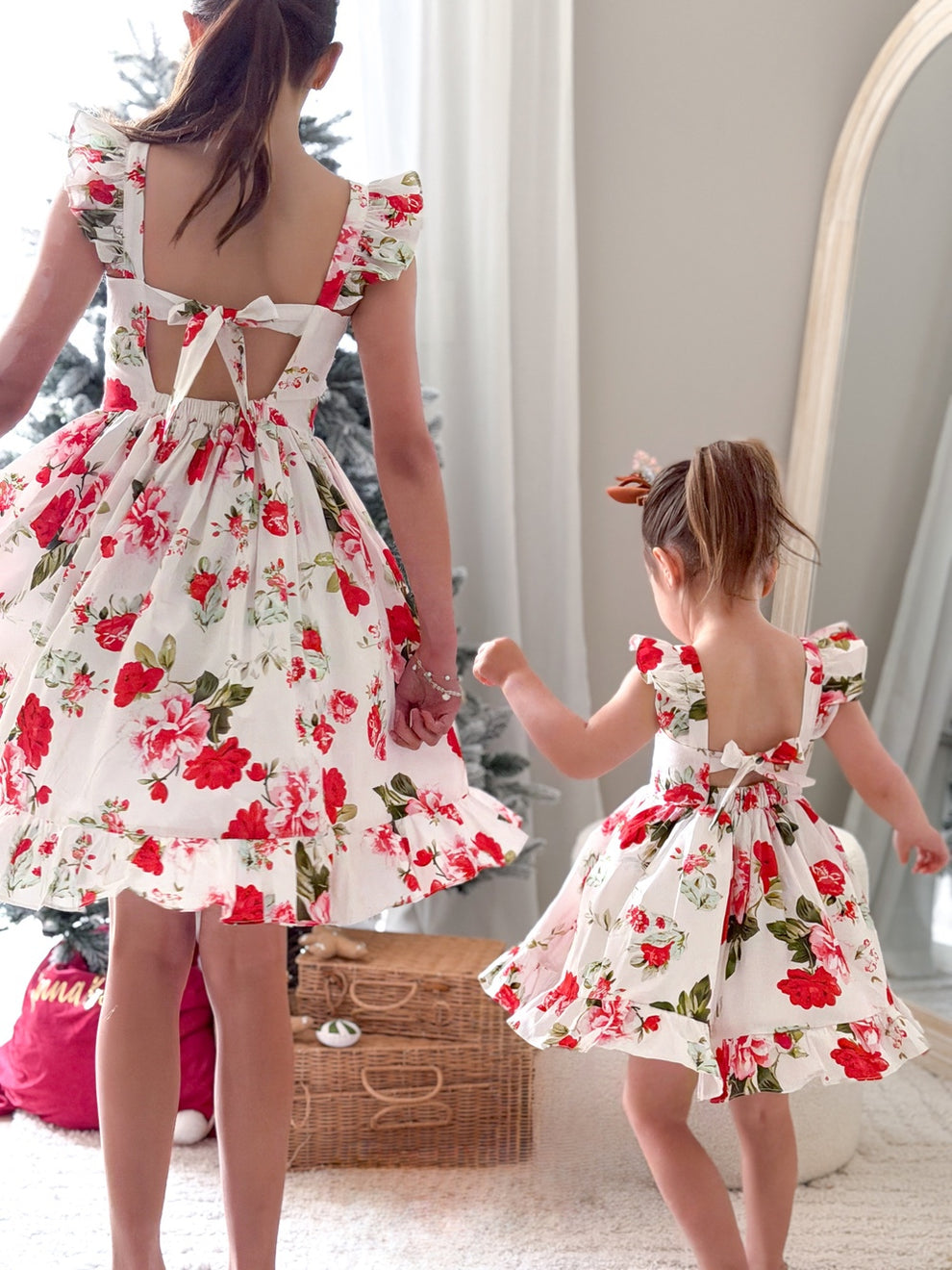 Matching Christmas sister dresses for 10-year-old and toddler in festive family photo
