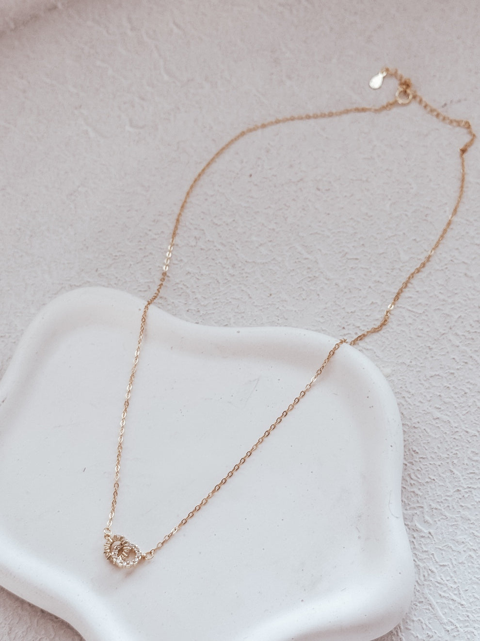 Girls gold necklace on display with linked circle charms