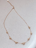 Close-up of daisy charm details on girls gold necklace