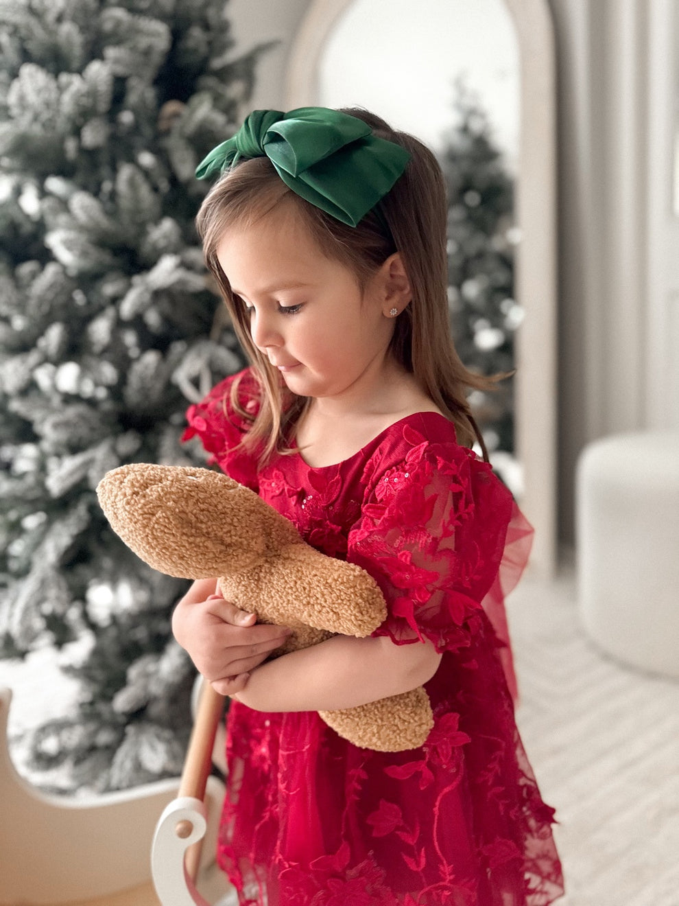 Toddler wearing green Christmas headband with big bow