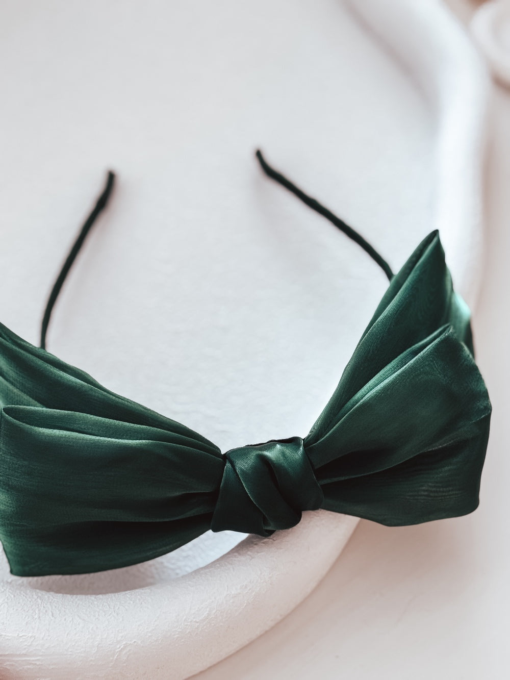 Close-up of festive green bow headband for holiday outfits