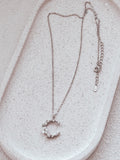 Close-up of Halo Blossom Girls Silver Necklace showing crescent moon and flower charm