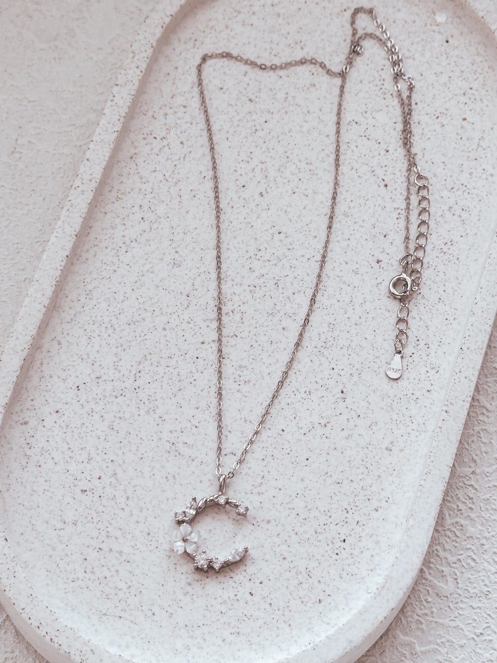 Close-up of Halo Blossom Girls Silver Necklace showing crescent moon and flower charm