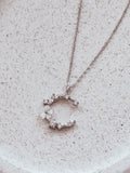 Sterling silver girls necklace with moon and floral detail on jewellery stand