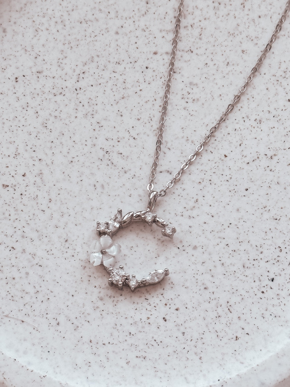 Sterling silver girls necklace with moon and floral detail on jewellery stand