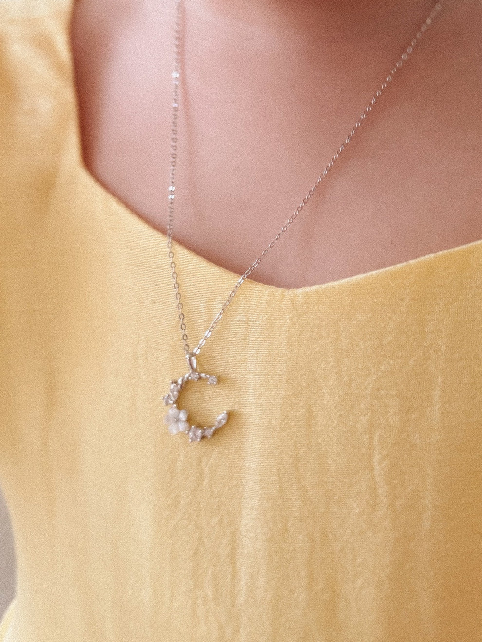Side angle of Halo Blossom necklace sparkling under soft light
