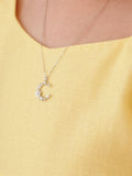 Close-up of moon charm with diamantes and single white flower