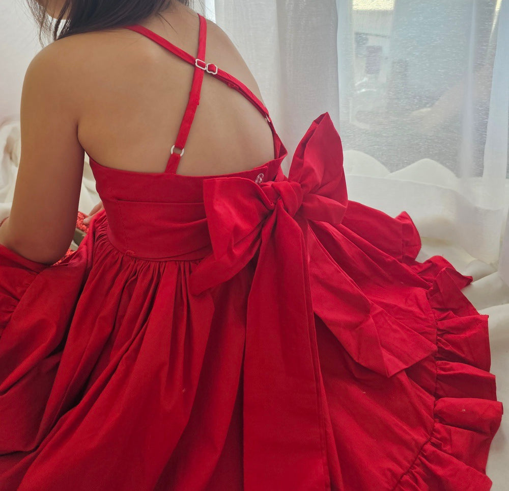Close-up of big red bow detail on the back of cotton girls Christmas dress