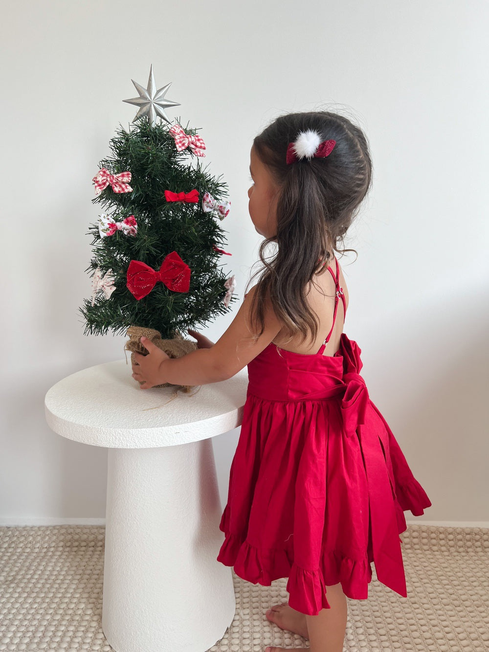 Back view of red Christmas dress showing big festive bow and flared skirt