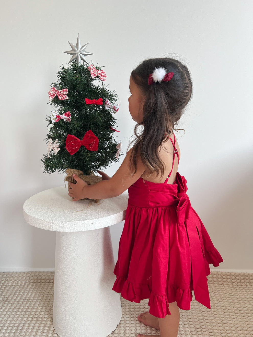 Back view of red Christmas dress showing big festive bow and flared skirt