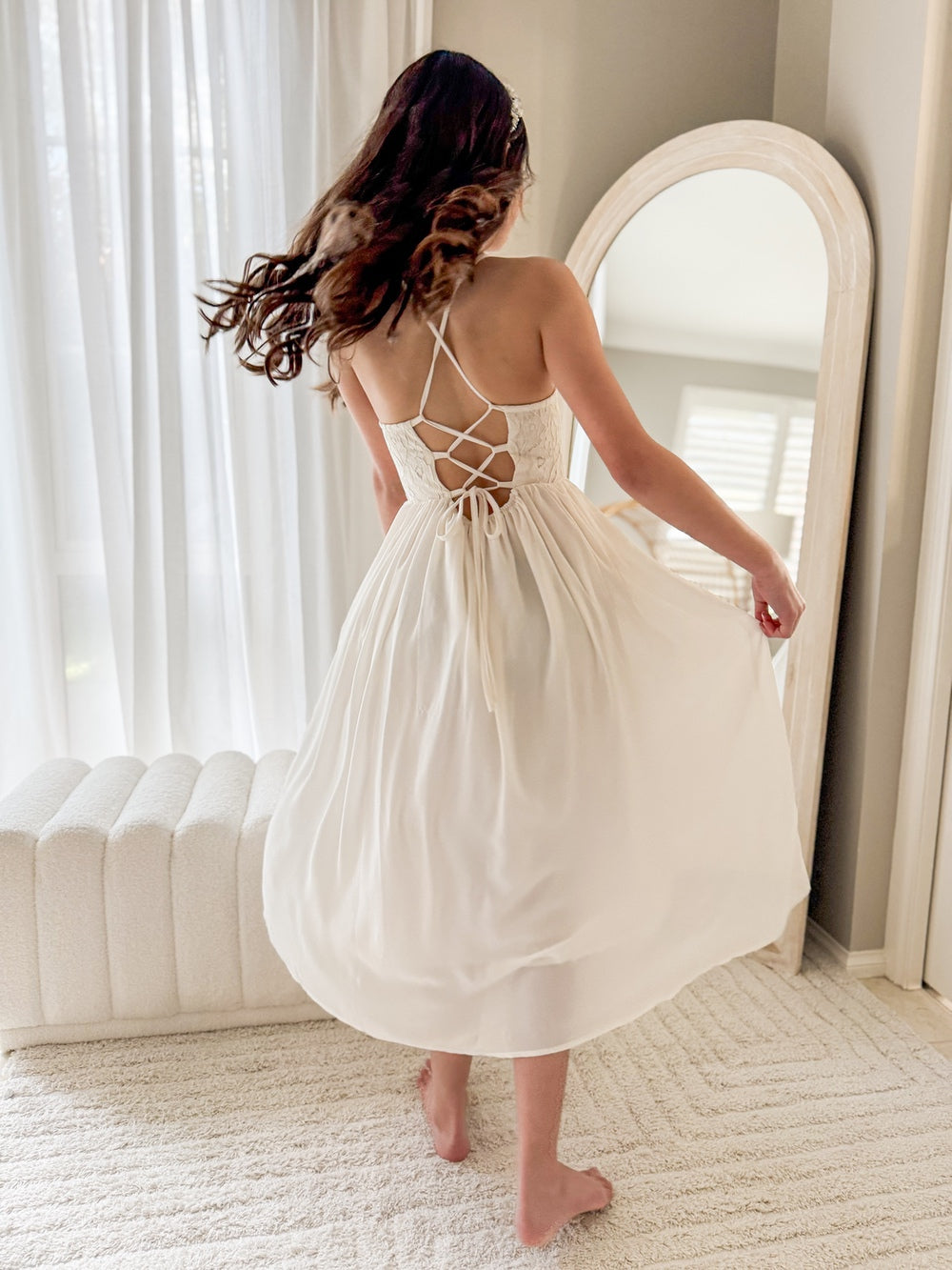 Model twirling in ivory flower girl dress with long chiffon skirt