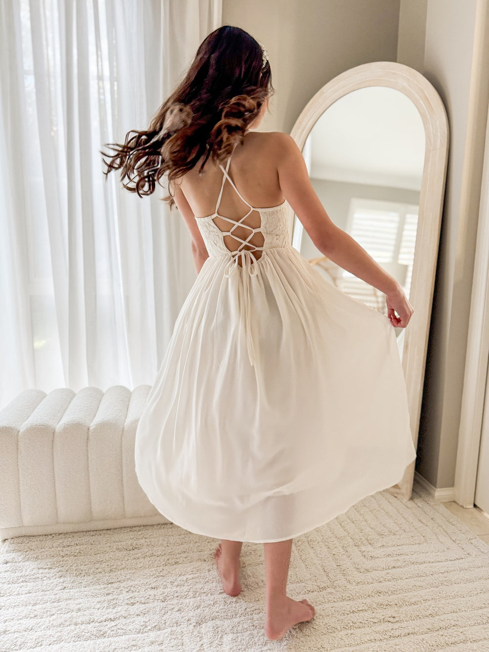 Model twirling in ivory flower girl dress with long chiffon skirt