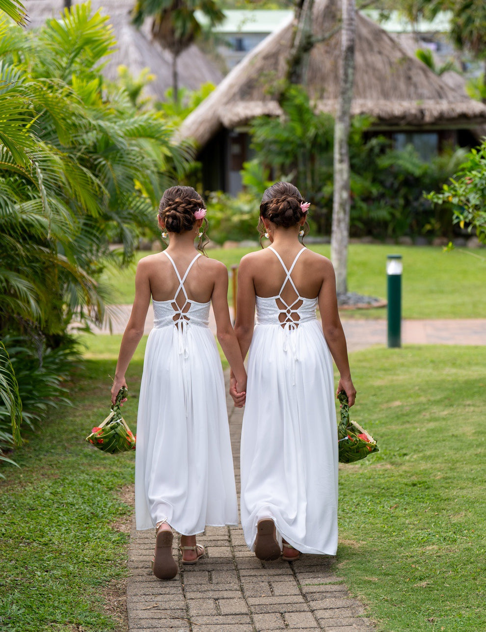 Back view of two girls wearing Isabelle lace bodice flower girl dresses with elegant lace-up backs