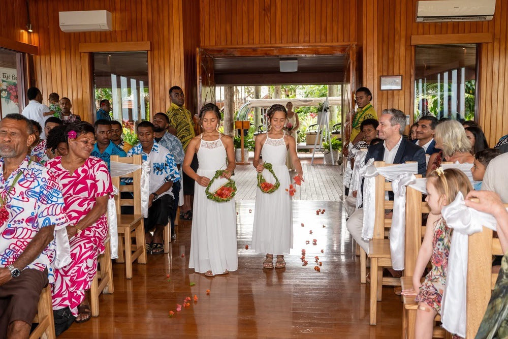 Two flower girls throwing flowers down the isle in matching Isabelle Dresses with lace-up backs and soft chiffon skirts