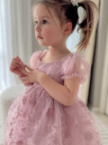 Girl sitting with skirt spread in dusty pink dress
