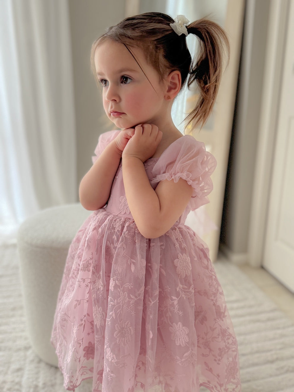 Girl wearing Isla Rose dusty pink flower girl dress from the front, standing elegantly