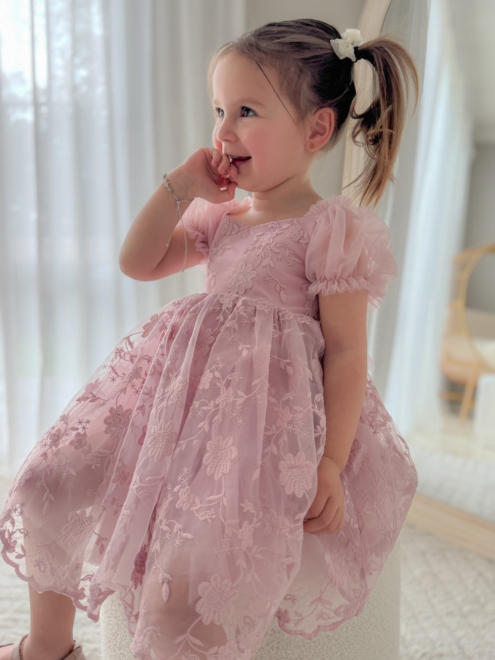 Full-body shot of model in dusty pink flower girl dress with gentle flare