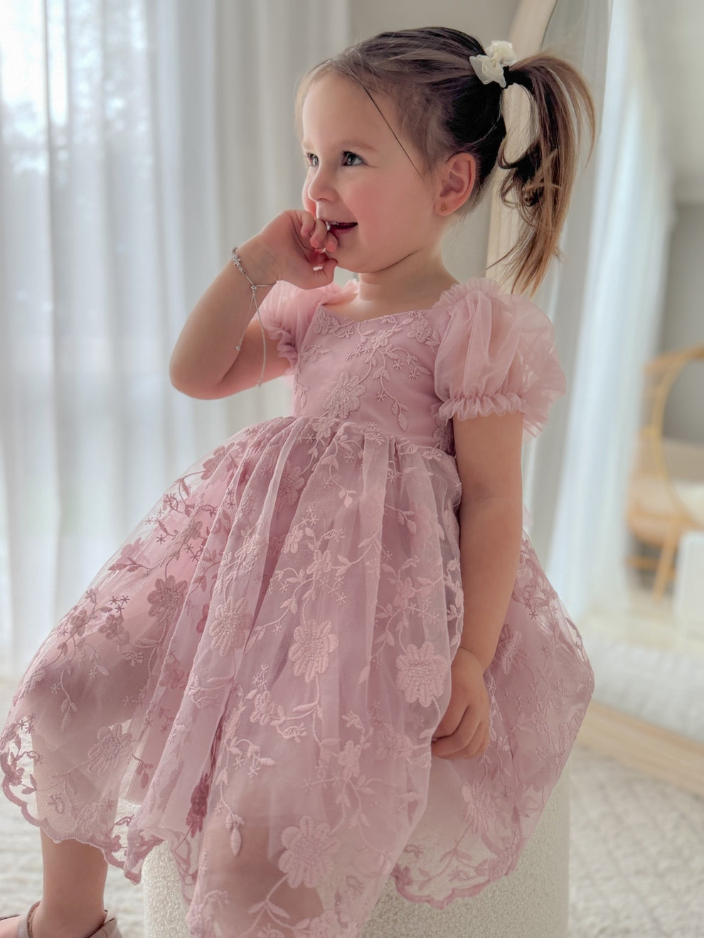 Full-body shot of model in dusty pink flower girl dress with gentle flare