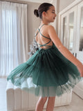 Girl twirling in green tulle dress with lace-up back design