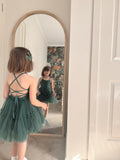 Juniper green Christmas dress reflected in a mirror, showing the front bodice and crisscross back.