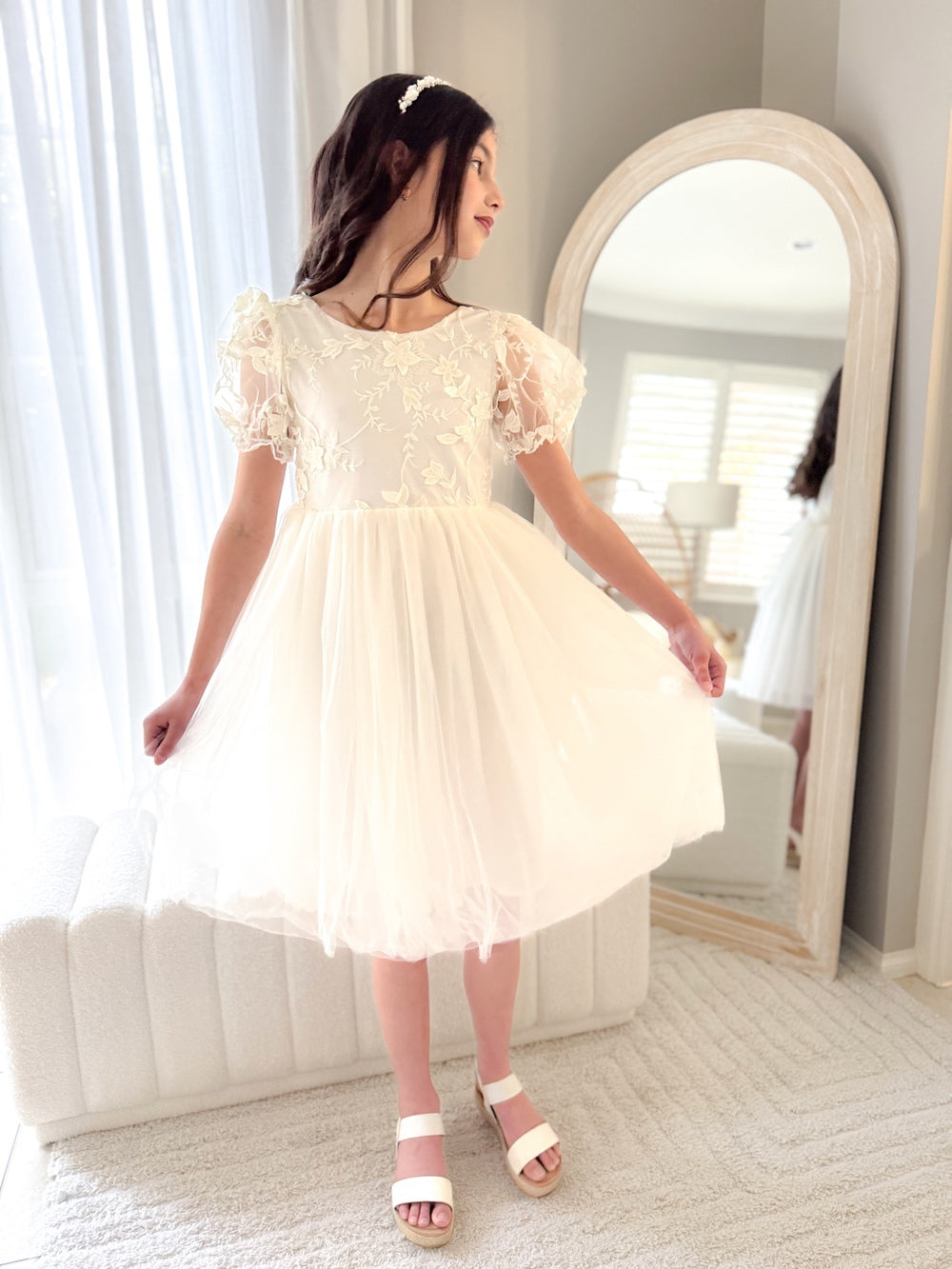 Close-up of embroidered bodice and soft puffed sleeves in ivory