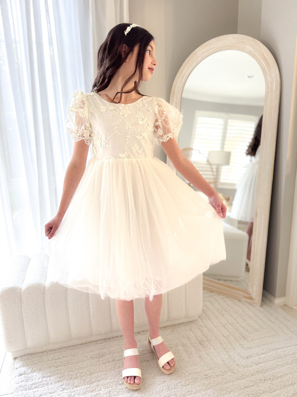 Close-up of embroidered bodice and soft puffed sleeves in ivory