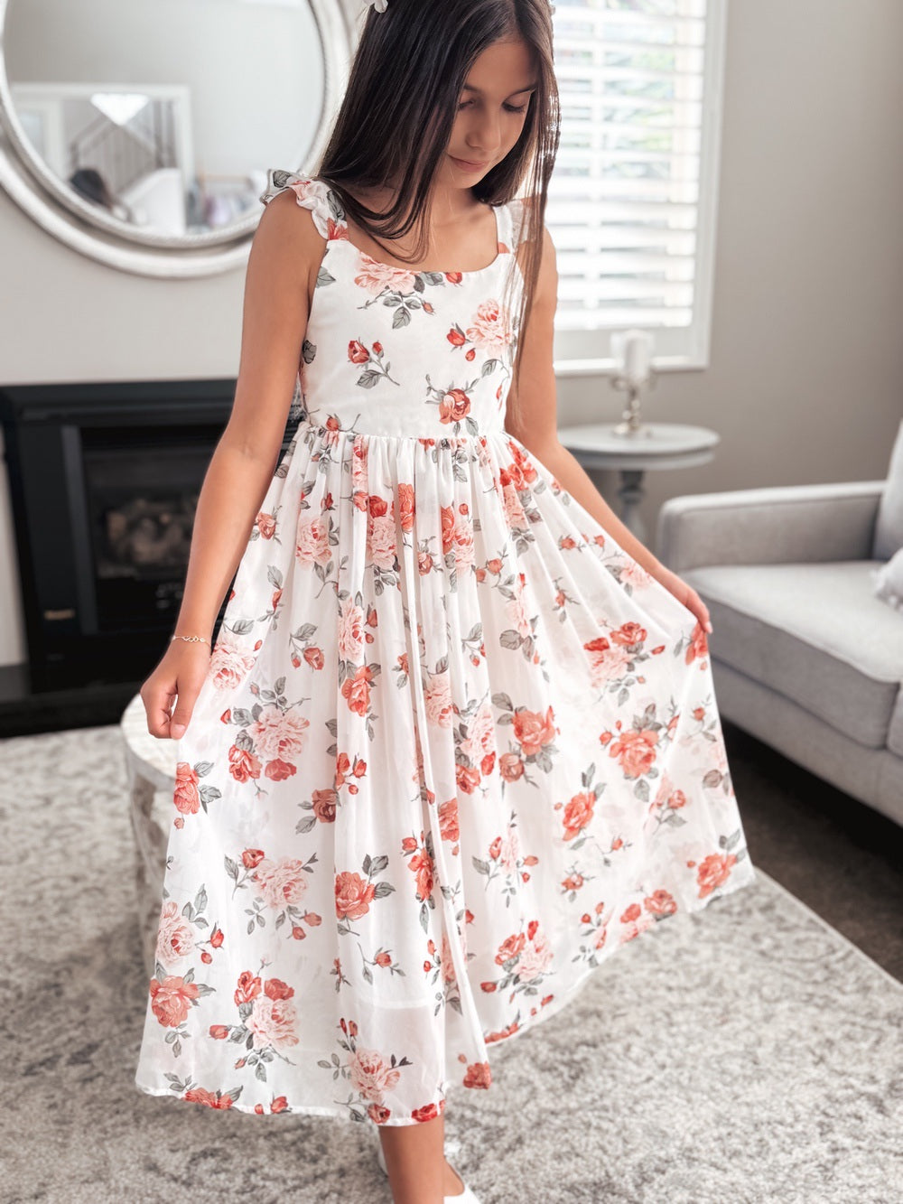 Tween girl wearing Leilani red floral dress front view – tea-length with ruffle shoulders