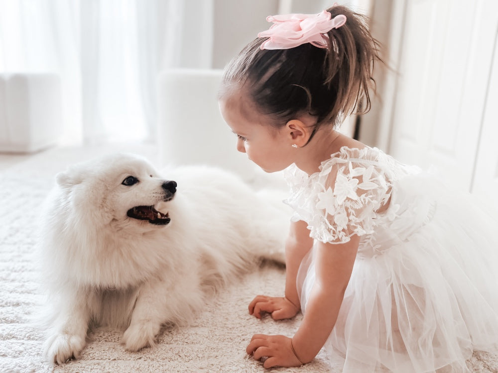 Lifestyle photo – baby wearing Lila White Embroidered Baby Dress for baptism or wedding
