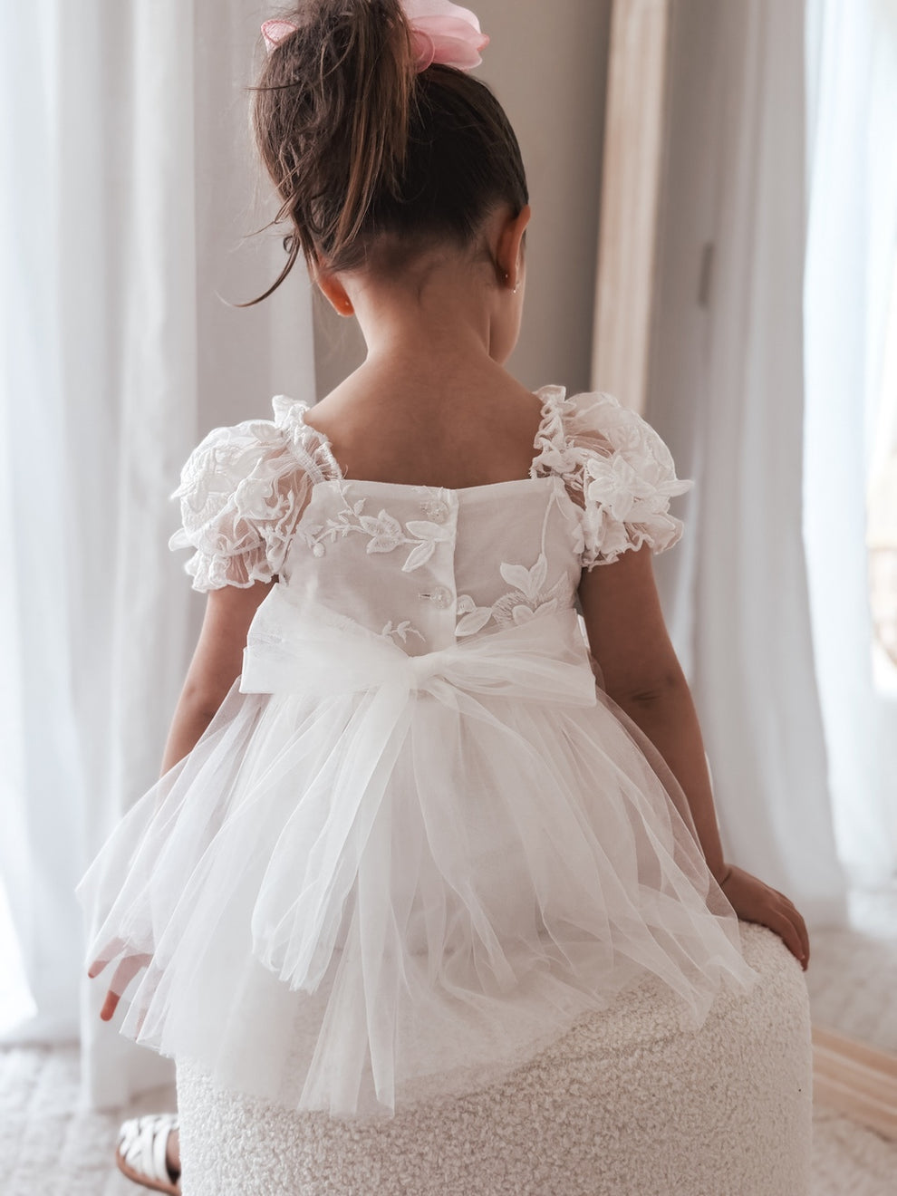 Back view of Lila White Embroidered Baby Dress showing button closure and tulle bow