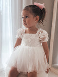 Front view of Lila White Embroidered Baby Dress – puff sleeves and embroidered detail