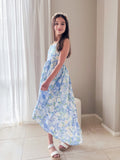 Girl in floral high-low dress twirling, soft fabric in motion