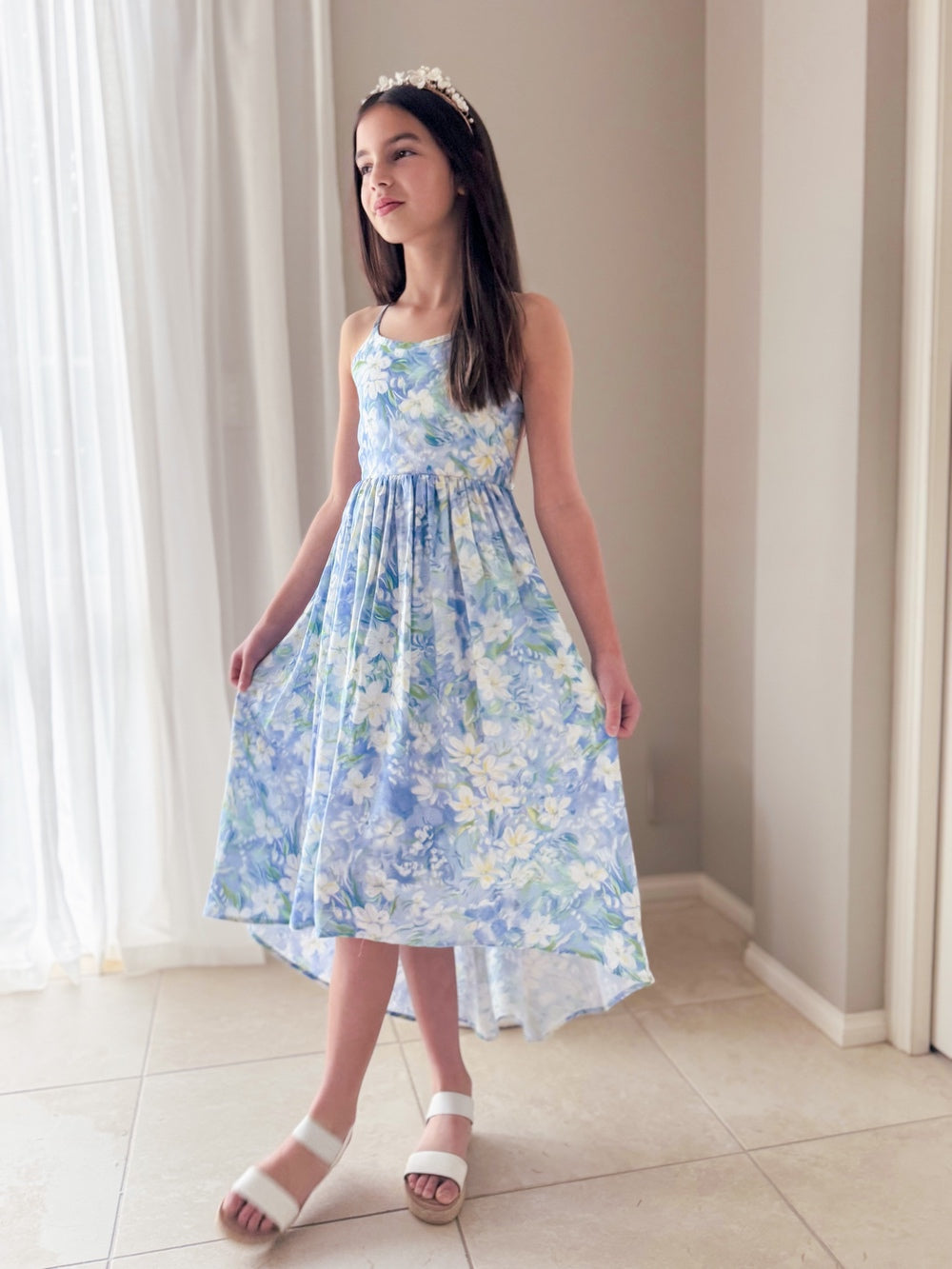 Girl wearing Bluebelle Floral High-Low Dress standing front-on in bright setting