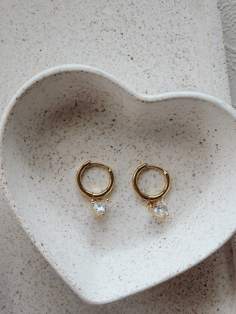 Flat lay of Love Heart Girls Gold Hoop Earrings – polished gold finish and heart charm
