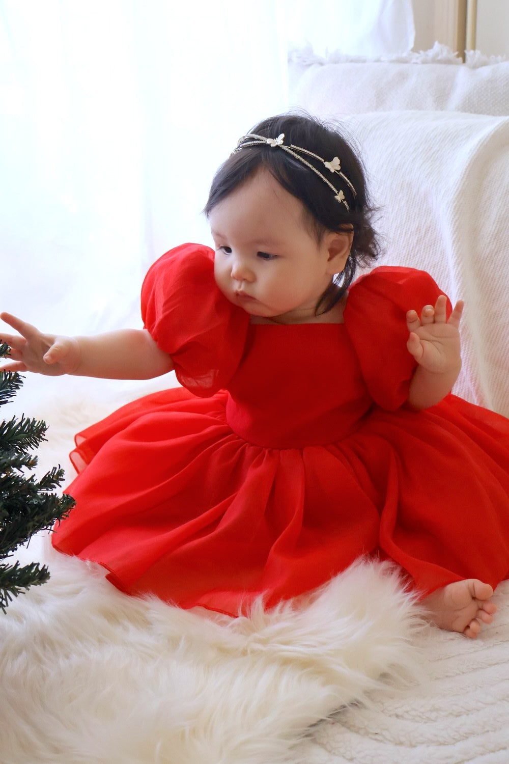 Lucy Baby Girls Red Christmas RomperBaby girl wearing Lucy red Christmas dress with puff sleeves and bow back