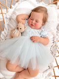 Lila dusty blue baby first birthday dress with a full tulle skirt.