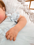 Lila dusty blue embroidered baby dress, floral puff sleeve close-up.