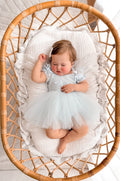 Lila dusty blue embroidered baby dress, overhead view.