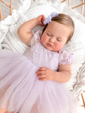 Baby girl wearing a lilac tulle dress with floral embroidery