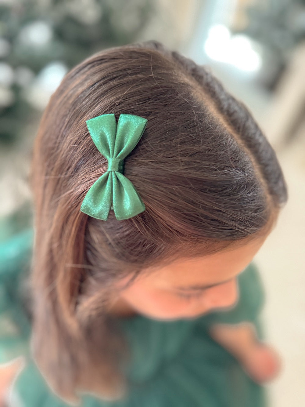 Mini green Christmas pigtail bows styled with festive dress