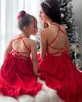 Matching sister red Christmas dresses in with crossover back