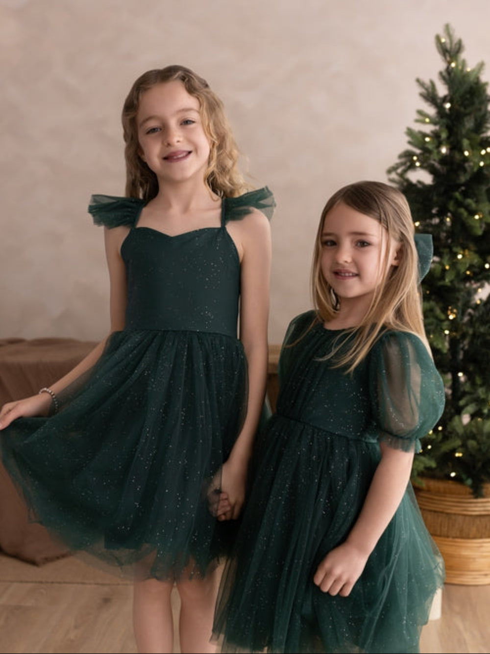 Sparkly green girls dress modelled eith matching sister dress