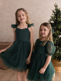 Sparkly green girls dress modelled eith matching sister dress