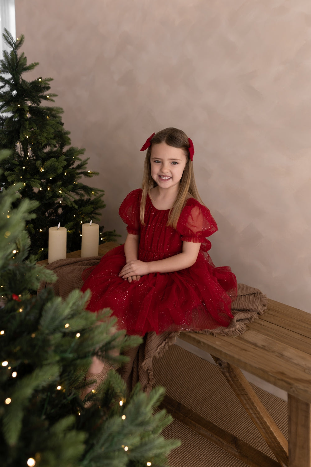 Girls red sparkly Christmas party dress modelled siting