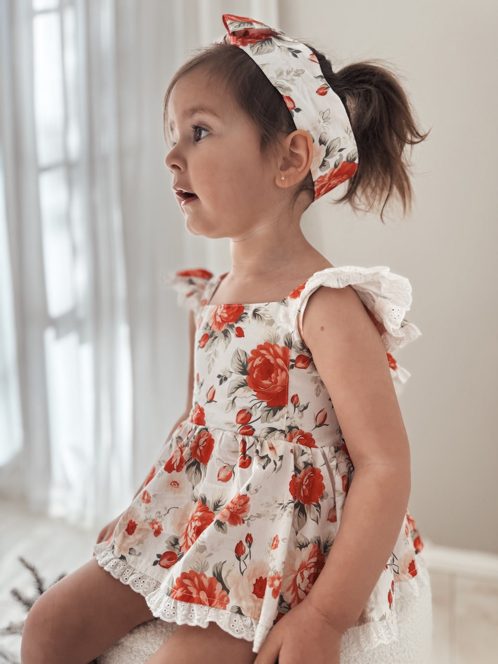 Olive Baby Girls Floral Christmas Romper - Christmas Dresses and RompersSeated pose showing broderie anglaise details and festive colours