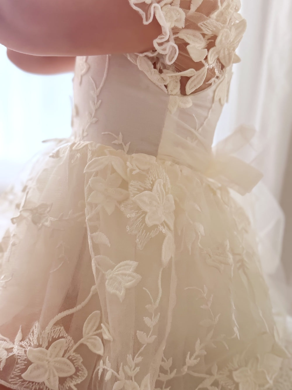 Close-up of embroidery detail on Petal Ivory Baby Dress bodice and skirt