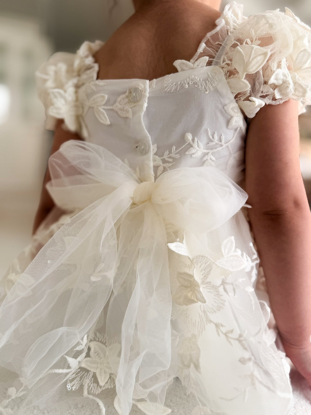 Petal Ivory Embroidered Baby Dress - Baptism DressesBack view of Petal Ivory Embroidered Baby Dress showing three-button closure and tulle bow