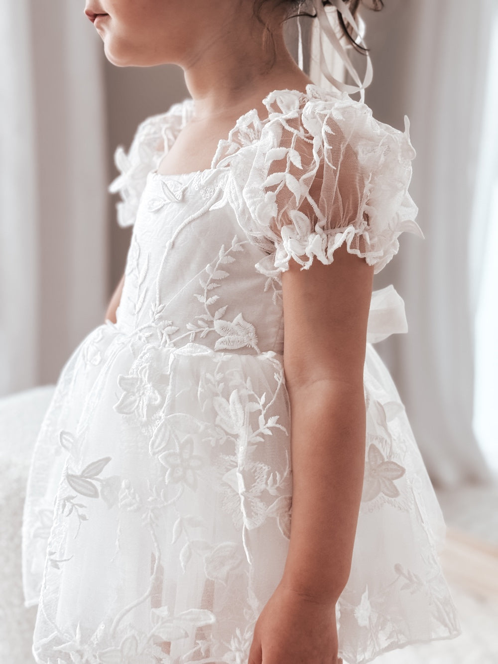 Lifestyle photo – baby wearing Petal White Embroidered Baby Dress for christening or wedding