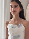 Close-up of girls silver necklace with diamante circle and flower motif
